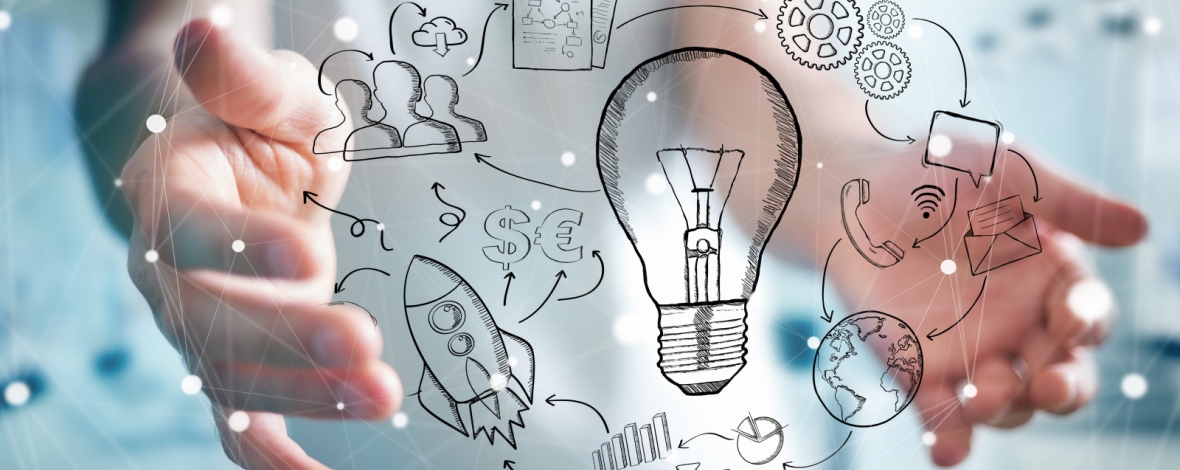 Une ampoule autour de laquelle tourne des objets entre deux mains