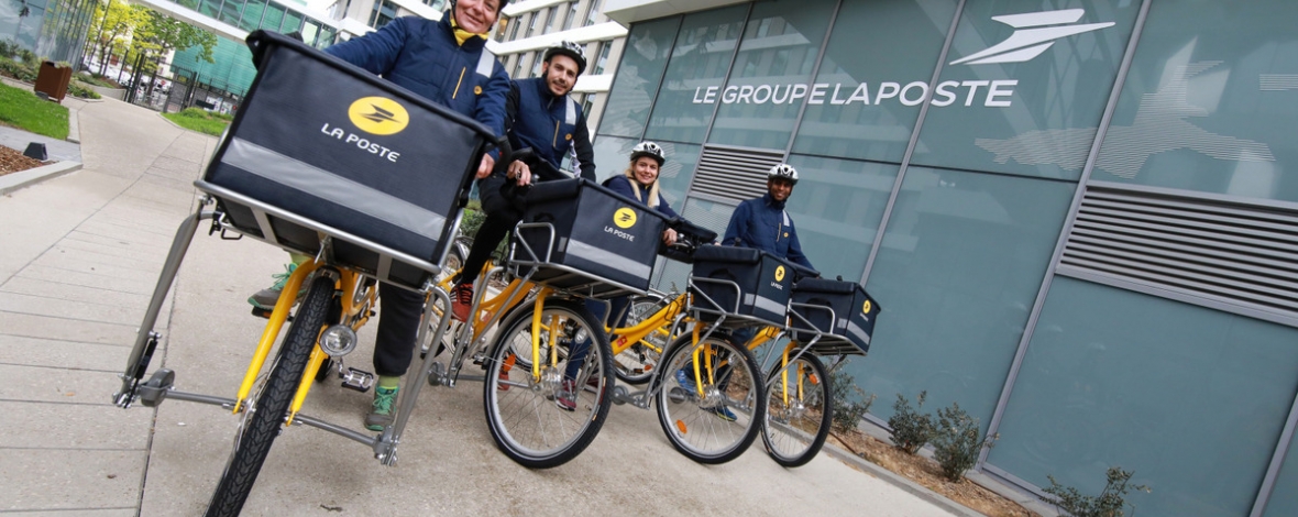 Photo de facteurs à vélo devant le siège du Groupe